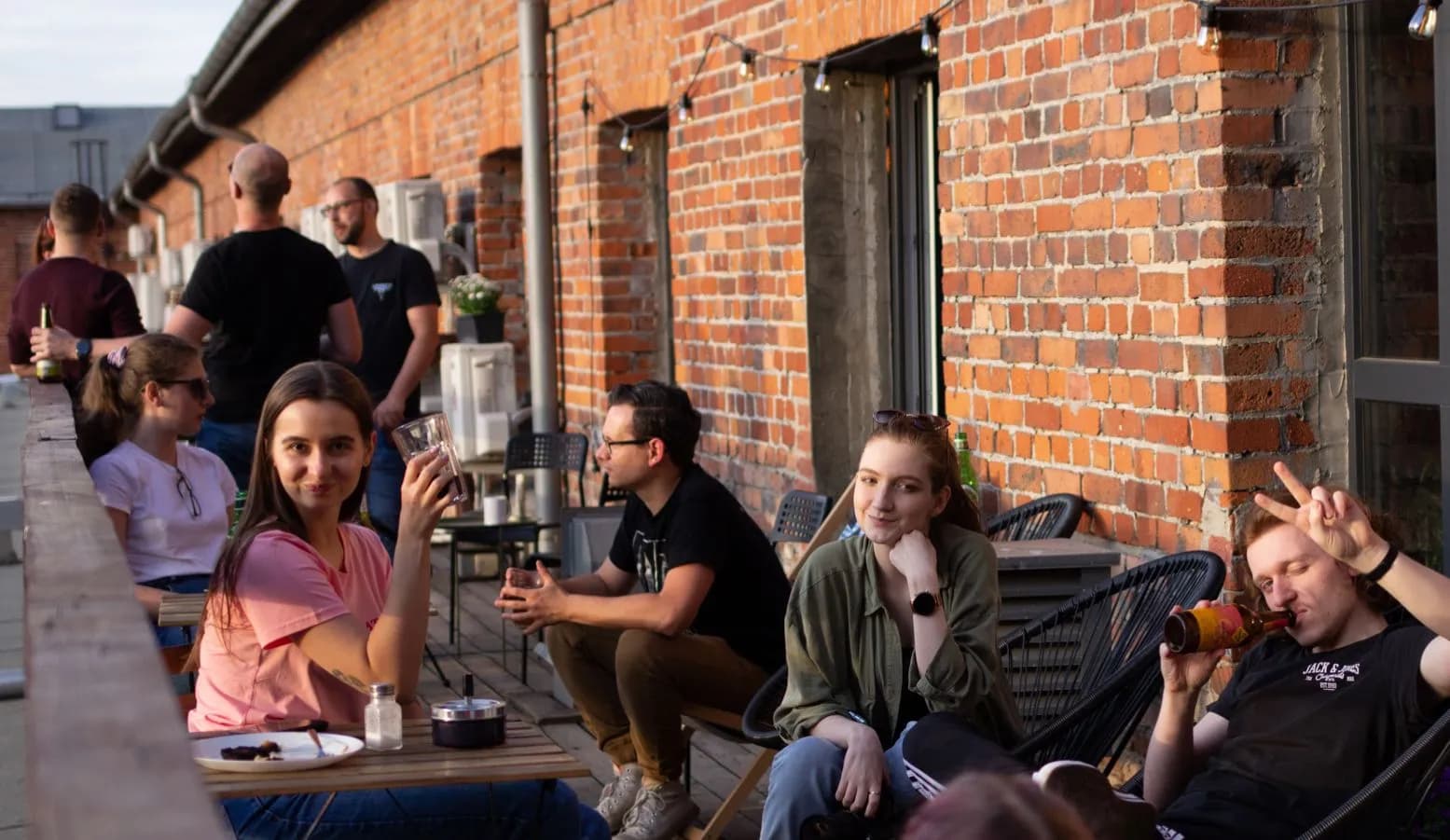 A group of Revolve Healthcare employees chilling on the terrace of the company’s office with the building wall made of exposed red bricks